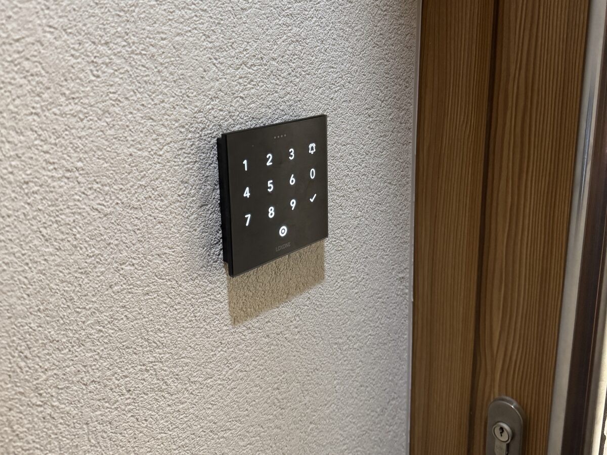 Loxone NFC Code Touch u dveří hotelového pokoje — bezklíčový vstup číselným kódem vygenerovaným při check-inu z PMS